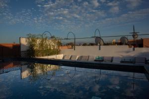 Le Pavillon de la Kasbah & SPA Marrakech في مراكش: مسبح وكراسي صالة