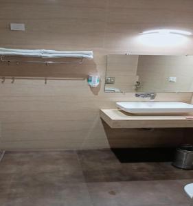 uma casa de banho com um lavatório branco e um espelho. em Lavanya Hotel- Near Alipur, Delhi em Nova Deli