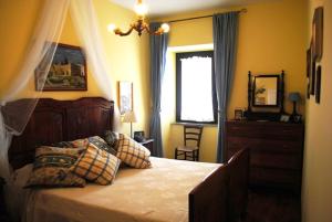 a bedroom with a bed and a dresser and a window at The garden of history in Bolsena