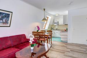 班辛海的住宿－Seehof Wohnung 1.33，客厅配有红色的沙发和桌子