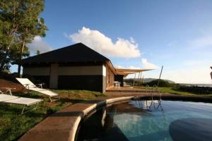 a house with a swimming pool next to a building at Altiplanico Rapa Nui in Hanga Roa