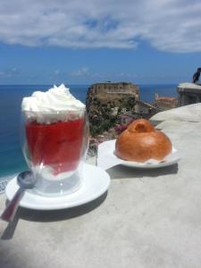 シッラにあるScilla Soleのテーブルの上に置かれた飲み物とペストリー