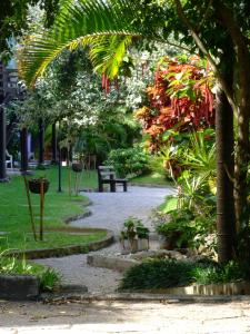 un parc avec des bancs et des arbres et un chemin dans l'établissement Chalés Saint Germain, à Florianópolis