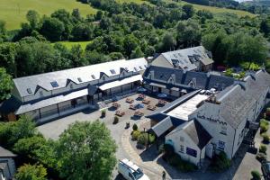 une vue aérienne sur un grand bâtiment avec un parking dans l'établissement Loch Ness Inn, à Drumnadrochit