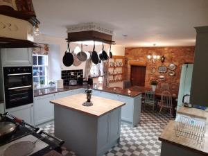 uma cozinha com armários brancos e uma bancada em West Wing Lickleyhead Castle em Auchleven