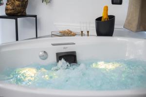 a bath tub filled with blue water with a fireplace at NM Luxury Suites in Pompei