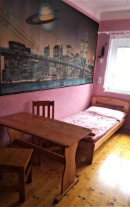 Cette chambre comprend un lit, une table et un banc en bois. dans l'établissement Penzion Apartmány Bečov, à Bečov nad Teplou