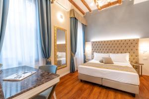 1 dormitorio con cama, escritorio y espejo en Residenza La Duchessa Deluxe Rooms, en Venecia