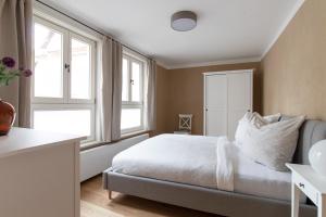 een slaapkamer met een bed en 2 ramen bij Ferienwohnung Lukas - Lehm erleben in Tangermünde