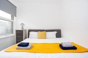 a bedroom with a large bed with two towels on it at The Chase by Sorted Stay in Southend-on-Sea