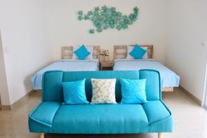 a blue couch in a room with two beds at Ocean Star Apartment Sanur in Sanur