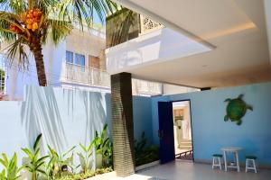 ein Haus mit einer Palme und einer blauen Wand in der Unterkunft Ocean Star Apartment Sanur in Sanur