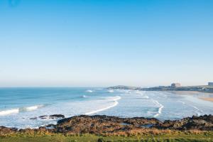 a view of a beach with rocks and the ocean at Fistral Beach Hotel and Spa - Adults Only in Newquay