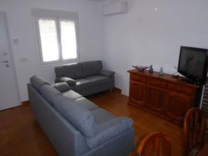 sala de estar con sofá y TV en Maison rénovée à 250m de la mer, en Santiago de la Ribera