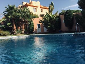 a swimming pool in front of a house at Marbella Deluxe Rooms in Royal Cabopino Townhouse in Marbella