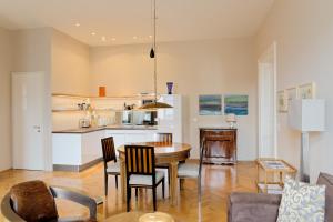 uma cozinha e sala de estar com mesa e cadeiras em Sissi - Schoenbrunn-Living perfect Apartments em Viena