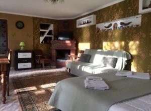 a living room with two beds and a fireplace at Garden House in Kvareli