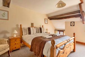 a bedroom with a large wooden bed in a room at Finest Retreats - Fives Court Cottage in North Cheriton