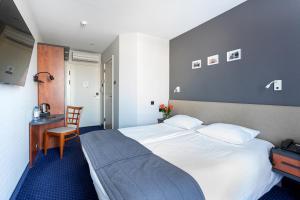 a hotel room with a large bed and a desk at Qubus Hotel Zielona Góra in Zielona Góra +44 photos