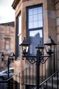 una fila de luces de la calle frente a un edificio en S.H Apartments, en Glasgow