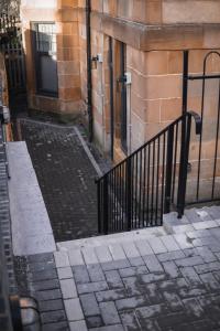 um edifício com um portão preto ao lado de um edifício em S.H Apartments em Glasgow