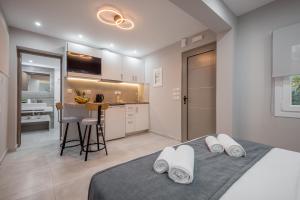 a bedroom with a bed with white pillows and a kitchen at Casa Rafaela 202 in Preveza