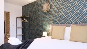 ein Schlafzimmer mit einem Bett und einer blau-grünen Wand in der Unterkunft Stylish Central Apartment inc Free Parking + Bedford City Centre + Hospital in Bedford