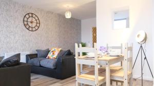 a living room with a table and a couch at Stylish Central Apartment inc Free Parking + Bedford City Centre + Hospital in Bedford