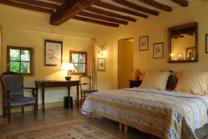 a bedroom with a bed and a table and a desk at Le Clos du Vivier in Valmont