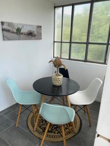 a table and chairs in a room with windows at Appartement verrière à deux pas des plages… in Hyères