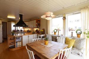 a kitchen with a wooden table and some chairs at Nice and comfortable villa at the historic Naset in the Gothenburg archipelago in Västra Frölunda