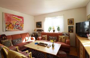 uma sala de estar com um sofá e uma mesa em Nice and comfortable villa at the historic Naset in the Gothenburg archipelago em Västra Frölunda