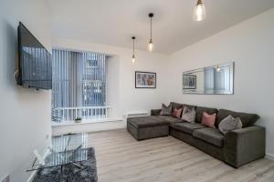 a living room with a couch and a flat screen tv at Casa Fresa - Seamen's Chapel in Dundee