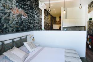 a bedroom with a bed and a stone wall at Punto Zero Suite in Corniglia