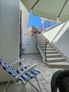 a balcony with a rocking chair and stairs at La Luna in Leuca