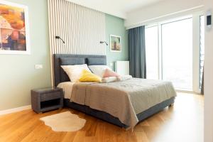 a bedroom with a bed and a large window at Capital Apartments Panorama in Poznań