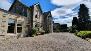 an external view of a house with a gravel driveway at Willows Bed & Breakfast in Pitlochry