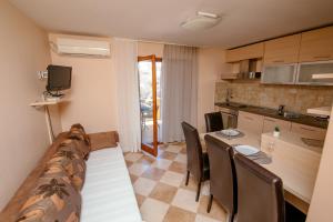 a kitchen and dining room with a table and chairs at M&M Apartments in Biograd na Moru