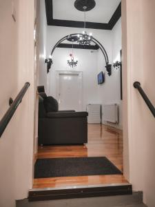 S.H Apartments في غلاسكو: غرفة معيشة مع أريكة سوداء في ردهة