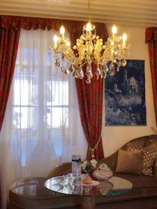 a chandelier in a living room with a couch and a table at Haus bei der Linden Ferienwohnungen in Schwangau