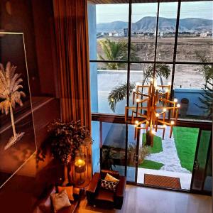 a room with a large window with a view of the desert at G R A N D C H A L E T in Salalah