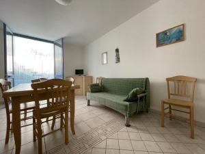uma sala de estar com um sofá, uma mesa e cadeiras em La Luna em Leuca