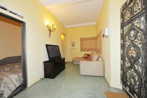 una camera da letto con un letto, una tv e un divano di Casa Costa Romantica a Genova