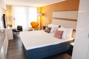 
a hotel room with a white bed and white comforter at Albus Hotel Amsterdam City Centre in Amsterdam
