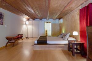 a bedroom with a large bed with a wooden ceiling at Friendly Rentals Monet in Barcelona