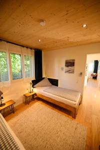 a bedroom with a bed and two tables and windows at Ferienhaus Haus im Garten in Feldkirch