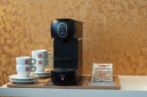 a coffee maker and two cups on a shelf at Albus Hotel Amsterdam City Centre in Amsterdam