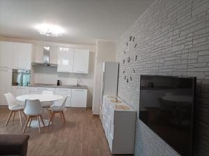a kitchen with a white table and a white brick wall at Casa Micaela in Chioggia