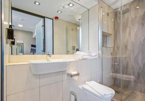 a white bathroom with a sink and a shower at Roomzzz Manchester Victoria in Manchester +42 photos