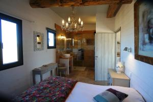 ein Schlafzimmer mit einem Bett und einem Waschbecken sowie ein Badezimmer in der Unterkunft Gîtes Equestres Lou Caloun - Les Saintes Maries de la Mer in Saintes-Maries-de-la-Mer